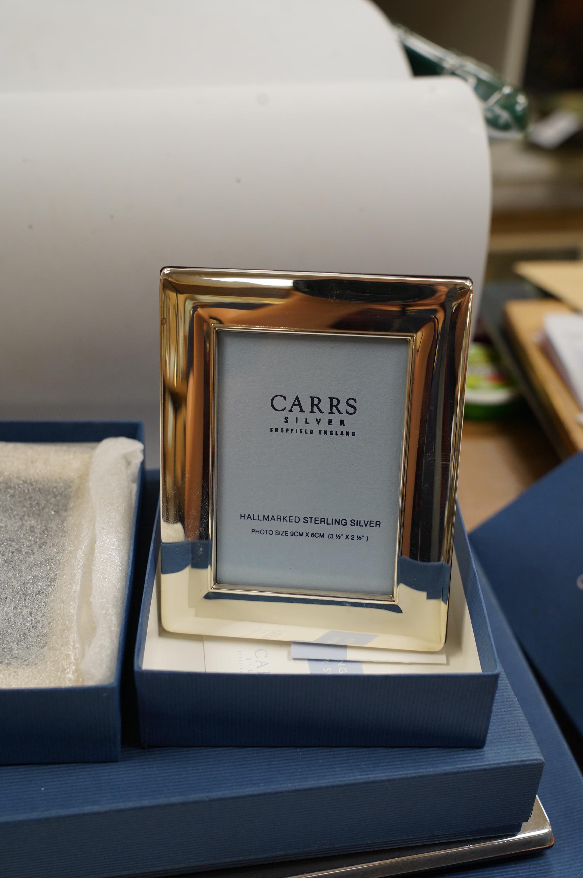 Four assorted modern Carr's of Sheffield, silver mounted photograph frames, three boxed, largest 24.2cm and a similar silver plated photograph frame, boxed. Condition - fair to good